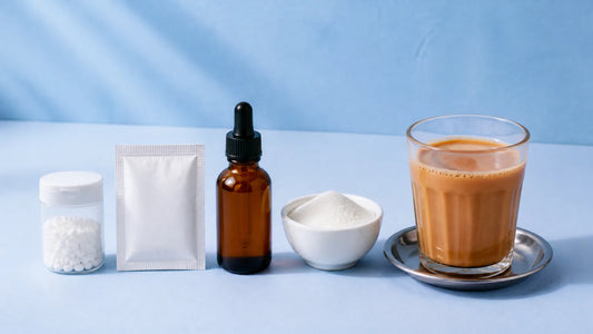 Sweetener tablets, a sachet, a drops bottle and a bowl of white powder beside a cup of chai